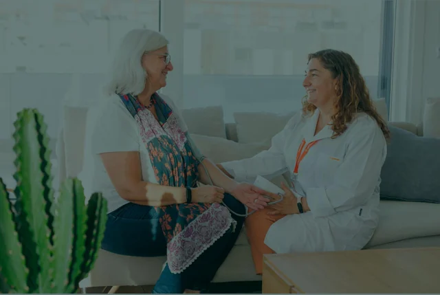 A home healthcare professional is attending to a patient in their own home.